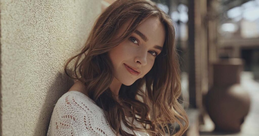 pretty young woman looking at camera near building of shopping mall.