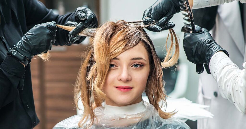 Hairdresser is dying female hair